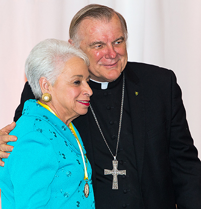 Barbara Romani of Our Lady of Guadalupe Church in Miami receives her Women of Faith award from Archbishop Thomas Wenski.