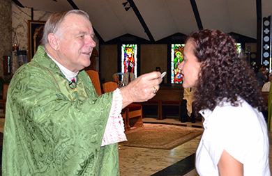 Archbishop Thomas Wenski serves Holy Communion at the ThanksForGiving Mass at St. Clement Church, in Broward.