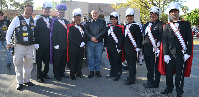 Archbishop Thomas Wenski poses with Knights of Columbus, including Sir Knight John Pesce, far left, president of the Florida State Knights on Bikes.