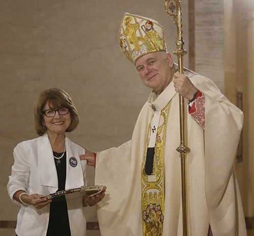 Vicky Oramas of Mother of Christ Parish in Miami receives her One in Hope award from Archbishop Thomas Wenski. She and her husband Carlos founded PAC - Por Amor a Cristo - an organization which teaches people about stewardship.