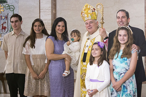 The Rodicio family poses with Archbishop Thomas Wenski after receiving their One in Faith award, from left: Pio, 15, Maria, 13, mom Lenore and Gabriela, 20 months, Ana, 9, Isabela, 11, and dad Sergio.