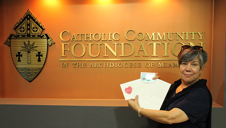 Monica Farias, the clinical coordinator at Catholic Charities'  Unaccompanied Refugee Minors program, displays the Target gift cards that will be given to children and young adults in the program for Christmas.