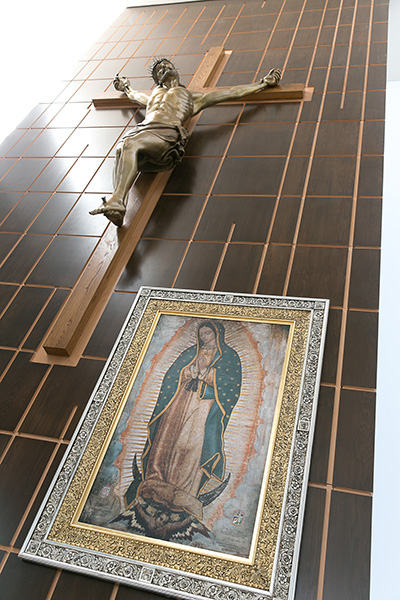 The bronze and wood crucifix that hangs on the altar of Our Lady of Guadalupe Church is accompanied by an image of the apparition that was touched to the original in Mexico.
