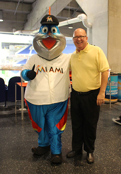 Little Flower's pastor, Father Michael Davis, poses with Billy the Marlin after the children's choir from his parish and school performed the national anthem.