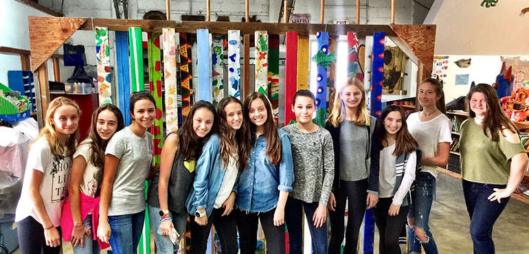 St. Hugh students pose for a photo after their training session at The Barnyard, aimed at helping them gain a more profound outlook on poverty. Pictured are: Bella Pennekamp, Maria Cardano, Olivia Samur, Isabella Gonzalez, Emiliana Antelo, Alexa Martinez, Helen Lobree, Chelsea Pennekamp, Sofia Rivero, Isabella Camargo, and Solange Aguero.