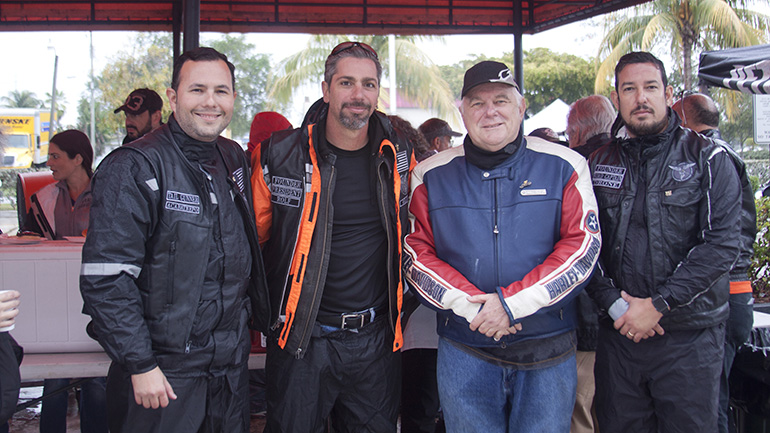 Archbishop Thomas Wenski stands next to members of the Emmaus Bikers from Our Lady of Guadalupe Church in Doral. From left: Rodolfo Moreno and Marcus Restrepos, and at far right, Victor Aneas. They are standing outside Peterson’s Harley Davidson in North Miami, the ending spot for the 2017 Archbishop’s Motorcycle Ride.