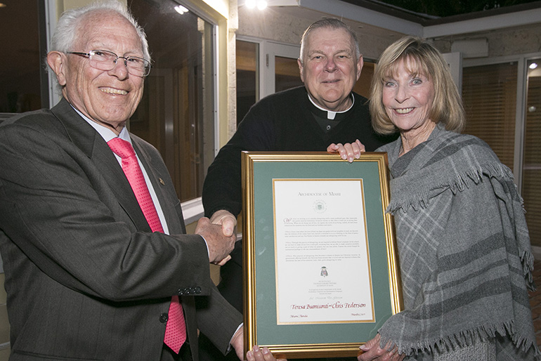 Archbishop Thomas Wenski inducts Chris Pedersen and Teresa Buoniconti, of St. Hugh Parish, Coconut Grove, into the A.M.D.G. (Ad Majorem Dei Gloriam) Society, recognizing those who have donated ,000 or more to the ABCD drive for five consecutive years.