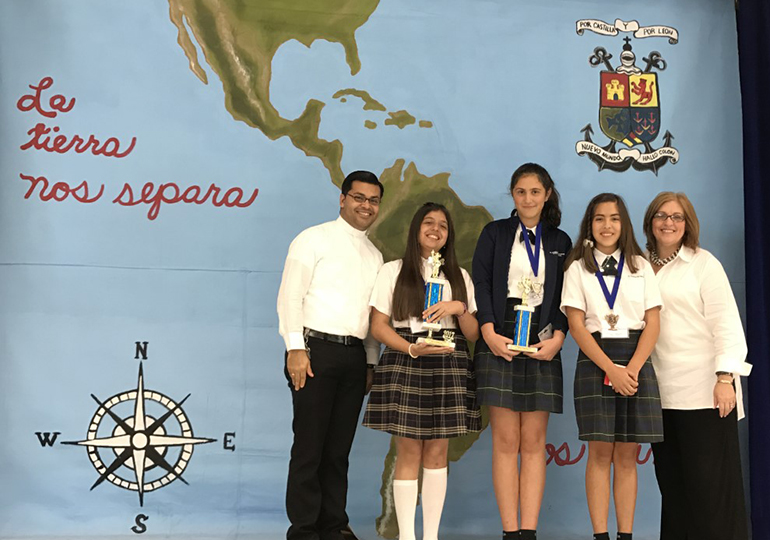 Father Yamil Miranda, parochial vicar at Blessed Trinity, and school principal Maria Teresa Perez pose with the Spanish Spelling Bee winners, from left: Andrea Schroeder, St. Andrew School, first place; and second and third place winners Camila Suels and Ana Serratos, both of St. Thomas the Apostle School in Miami.