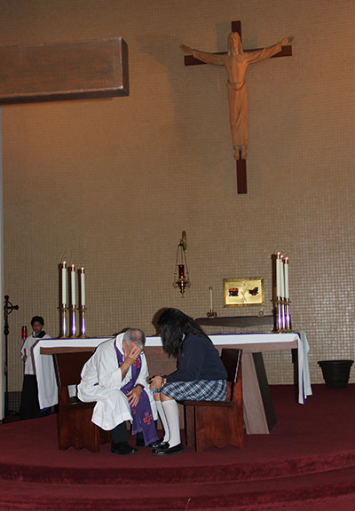 Father Gerardo Diaz, St. Michael's pastor, hears the confession of a St. Michael student.