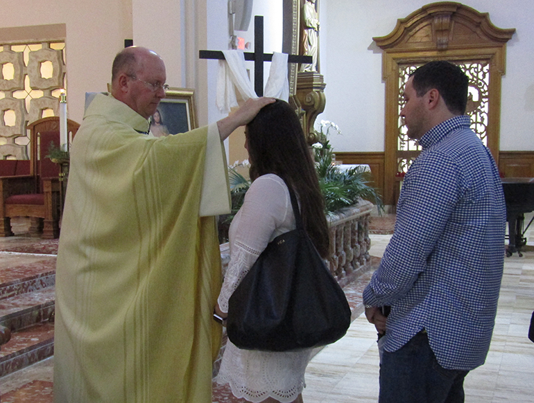 Father Michael Davis, Little Flower's pastor, anoints Vanessa and Alex Arvesu after the second annual Infertility Mass at the parish April 23. The start of National Infertility Awareness Week this year coincided with the second Sunday of Easter, feast of Divine Mercy.