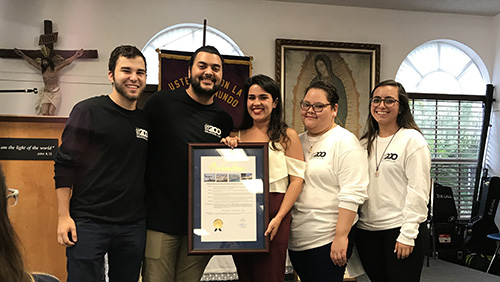 Happy Encuentros Juveniles Day! Encuentros Juveniles leaders, including Carlos San Jose, Mark Gomez, Rebecca Garcia, Sophia Bello Diaz and Sabita Perez pose with a framed proclamation presented by Miami Dade County Commissioner Esteban Bovo, Jr., declaring July 21 as Encuentros Juveniles Day in Miami Dade County.