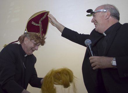 Payback: Bishop Noonan puts on a gag-miter given to him by his classmate in the seminary, Father Federico Capdepon. Over the years, they have kept track of who was going bald faster, so the miter brings with it a full head of red curly hair - and some to spare.