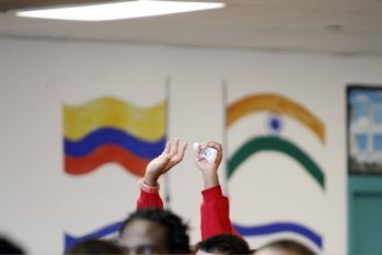 A detainee at Krome Service Processing Center raises his hand in praise during the celebration of Christmas Mass presided by Archbishop Wenski.
