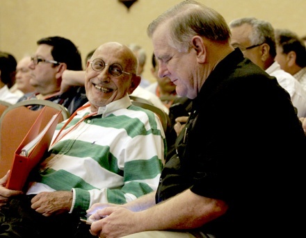 Father Roger Holoubek, pastor of St. Maurice in Dania Beach, shares a laugh with Archbishop Thomas Wenski during one of the sessions of the priests' convocation.
