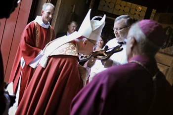 Bishop Estevez kisses the cross inside the Cathedral- Basilica of St. Augustine.