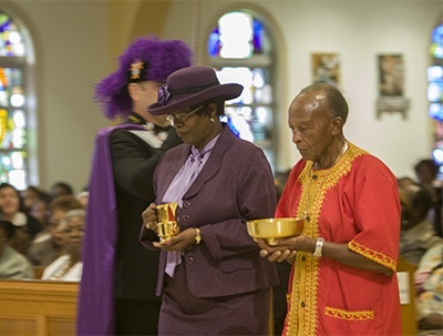 Katrenia Reeves-Jackman, director of the Office of Black Catholic Ministry, and Charles Thompson, president of the Black Catholic Implementation Team, take up the offertory.