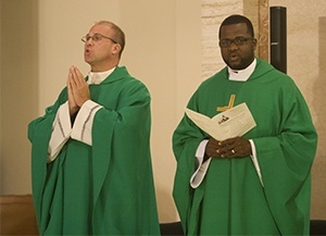 Father Christopher Marino, rector of St. Mary Cathedral, left, takes part in the Mass along with Father Chanel Jeanty, archdiocesan chancellor and pastor of St. Philip Neri Church in Miami Gardens.