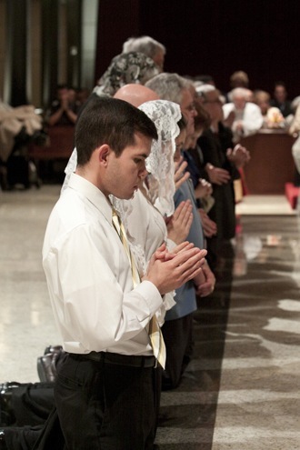Participants at the Mass kneel at the front of the altar in preparation for receiving Communion.