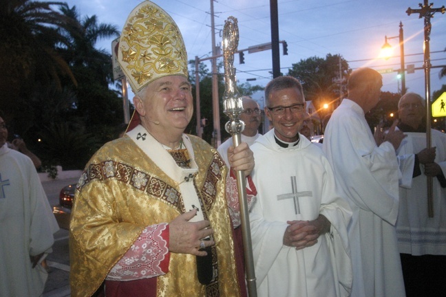Archbishop Thomas Wenski and Father John Baker wait to greet parishioners outside the basilica after the Mass.