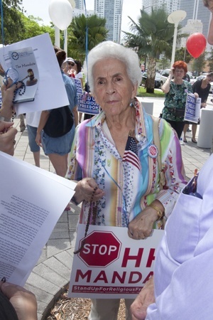 Romelia Gallego of St. Lawrence Parish in North Miami Beach prays the rosary with three others from her church outside the federal courthouse in downtown Miami.