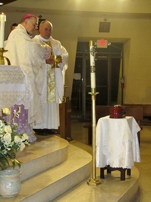 Con el P. Rumin Dominguez, rector de la Ermita, a su lado, el arzobispo Thomas Wenski bendice los restos mortales del arzobispo Francisco Oves, quien fue enterrado en Miami al morir en 1990 y quien descansará ahora en la catedral de La Habana.
