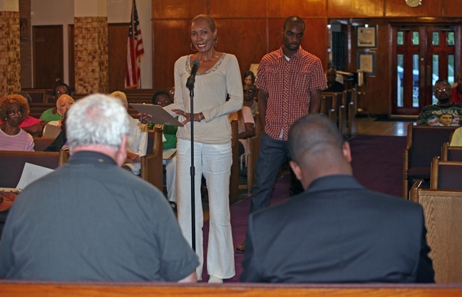 Verna Pegues addresses Oblate Missionary Father John Cox, left, and Father Chanel Jeanty.