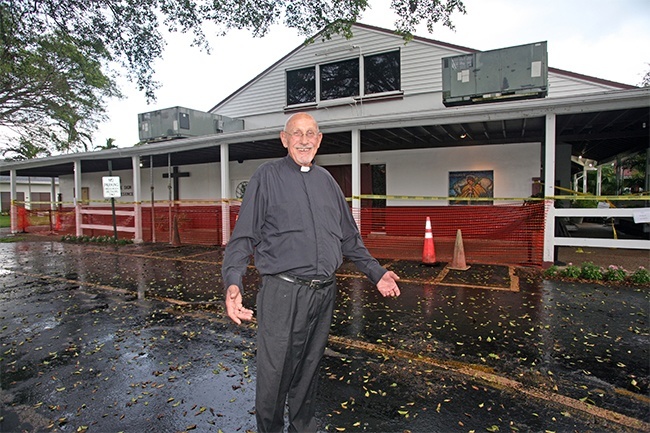 Father Roger Holoubek, pastor, poses in front of the entrance to St. Maurice Church, which is closed off because the awning is sagging.