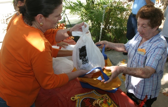 Esther Cabrera receives a donated turkey from a volunteer.