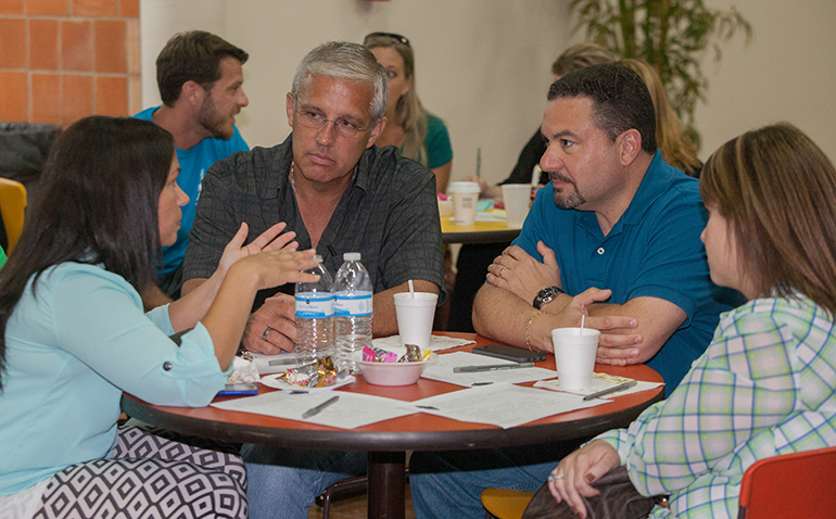 Youth ministers from Mother of Christ Church speak among themselves on youth ministry issues. From left: Idayme Vazquez, Carlos Vazquez, Jose Villafranca and Yurien Villafranca.