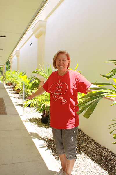 Joan Crown, Respect Life director, shows her appreciation for the generous donation of palm trees that line the breezeway at the new Respect Life Office in Hollywood.