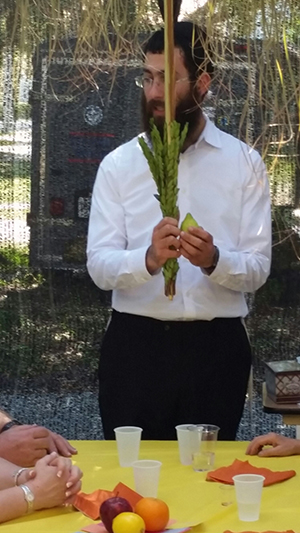 Rabbi Mendy Marlow of the Las Olas Chabad Jewish Center explains sukkot to an interfaith gathering of people with special needs.