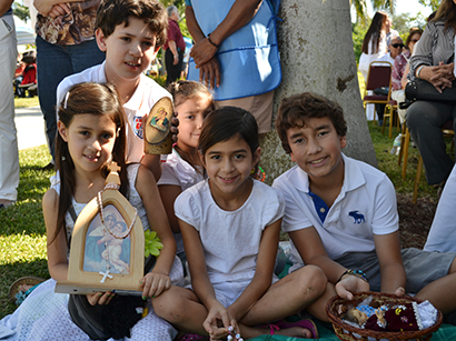 Posing with images that they brought to be blessed during the Mass, from left: Vecki Leitman, Lawrence Leitman, Analise Zea, Bella Leitman and Jose Zea.