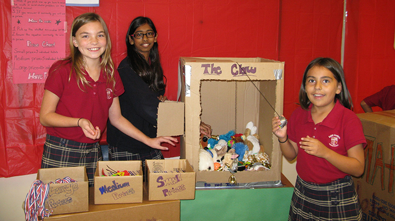 From left, St. Andrew students Allison Power, Katherine Dookhan and Valeria Bustos pose with the arcade game they created for the Imagination Foundation Global Challenge.