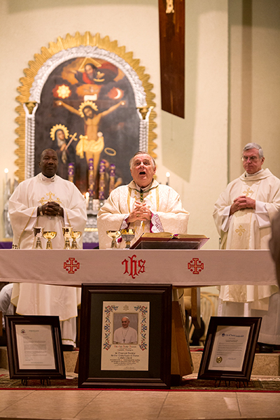 Miami Archbishop Thomas Wenski celebrates Mass for the community of Our Lady Queen of Heaven Parish in Fort Lauderdale during the 40th anniversary Mass and celebration for the parish, held Oct. 22. At left is current pastor, Father Kidney M. St. Jean, at right is former pastor, Father Gerald Morris.