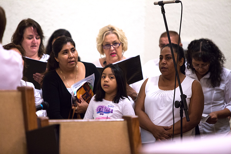 Multiethnic and multilingual choir members at Our Lady Queen of Heaven Parish in Fort Lauderdale sing during the 40th anniversary Mass and celebration for the parish, held Oct. 22.