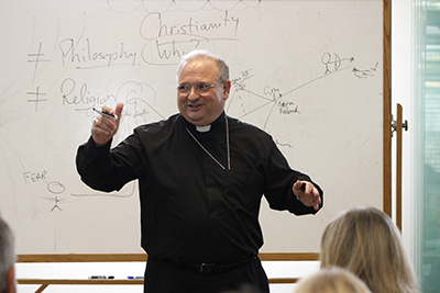 El Obispo Auxiliar Peter Baldacchino presenta animadamente un taller sobre Lumen Gentium, el documento del Vaticano II sobre la naturaleza misionera de la Iglesia.