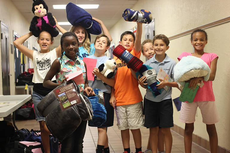 St. Gregory students pose with some of the items they collected to fill duffel bags for foster children as part of the "Bags 'n' Stuff" service project.