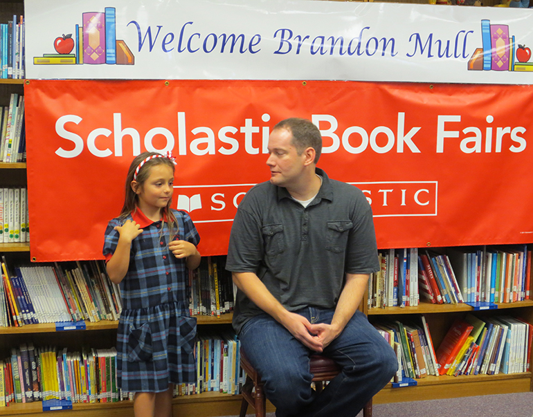 Author Brandon Mull takes time to have a one-on-one photo op with a  student from St. Mark.