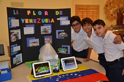 St. Agnes students, from left,  Ernesto Walter, Fernando de la Lama, and Juan Pablo Dibildox pose in front of their Hispanic Heritage project, which focused on Venezuela.