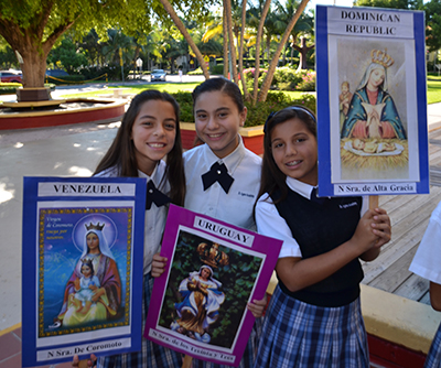 Holding up Latin American country's patron saints before the Hispanic Heritage Mass, from left, St. Agnes students Andrea Ulivi, Antonella Martinez, and Daniella Sanchez.