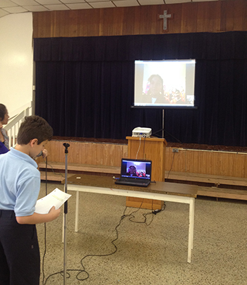 A Sts. Peter and Paul student asks a question of a Mexican student using the Skype app, while fellow students watch her response on the big screen.