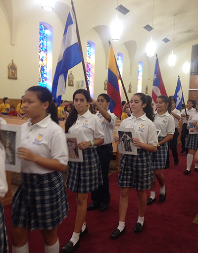 Students at Sts. Peter and Paul celebrate Hispanic Heritage Month by processing into Mass with flags and patron saints from the Hispanic nations of the Americas.