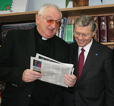 On a visit in 2010 to Archbishop McCarthy High School, Thomas Monaghan, president of Dominos Pizza and founder of Ave Maria University, enjoys time with Father Brendan Dalton.