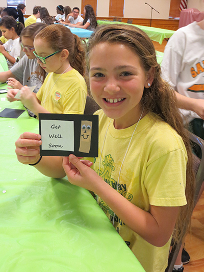 Sixth grader Brooke San Filippo shows the final product of her work at the St. Jude station. After making the get well cards, students at the St. Jude station helped fill chemo care packages for patients at the Joe DiMaggio Pediatric Oncology department.