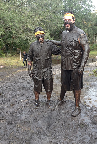 Transitional deacons Phillip Tran, left, of Miami and Chuck Dornquast of St. Petersburg pose after crossing the finish line of the Tough Mudder challenge held in Kissimmee Nov. 9.