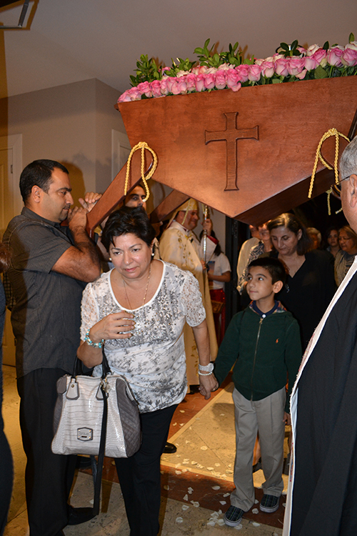 Parishioners of Our Lady of Lebanon walk under the relics of St. Rafqa upon entering the church.