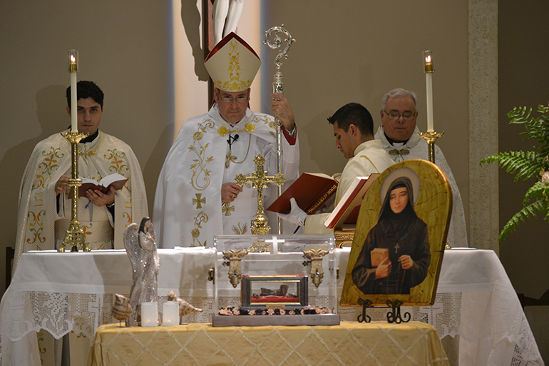 Chorbishop Michael Thomas, center, vicar general and chancellor of the Maronite Catholic Eparchy of St. Maron of Brooklyn, presides at the Mass with the relics of St. Rafqa. At left is Father Elie Saade, pastor of Our Lady of Lebanon Church.