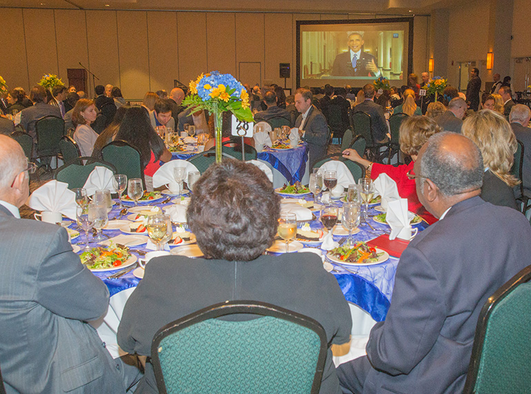 Immigration attorneys watch a livestream of President Obama's announcement on immigration during Catholic Legal Services' annual banquet and awards dinner.