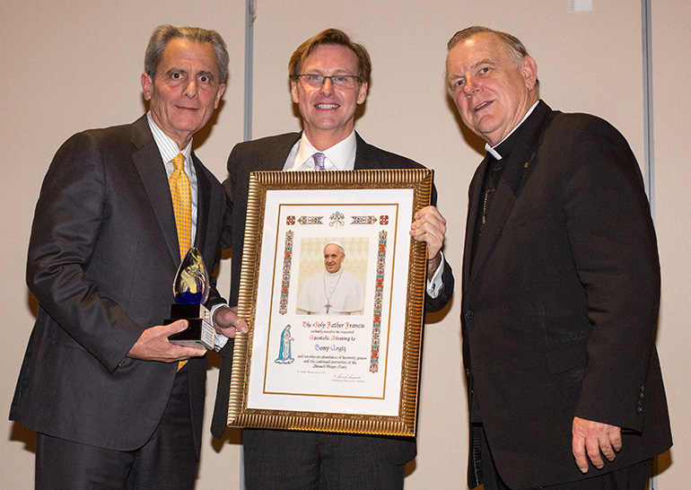 Accountant Tony Argiz, left, a Pedro Pan immigrant, receives his New American Award from Randy McGrorty, CEO of Catholic Legal Services, and Archbishop Thomas Wenski.