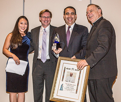 Enrique Gonzalez, III, third from left, an attorney who worked with Sen. Marco Rubio on immigration legislation receives Catholic Legal Services' Pro Bono Award from CLS board member Sui Chung, CEO Randy McGrorty, and Archbishop Thomas Wenski.